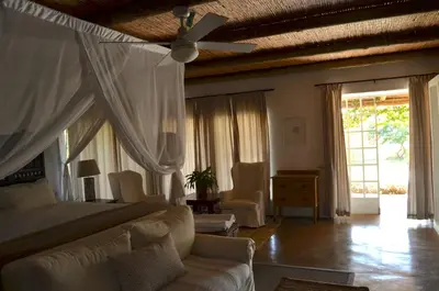 a bedroom with a bed and a ceiling fan at Ashbourne Country Escape Hazyview in Hazyview