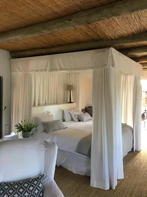 a bedroom with a large white bed with a canopy at Ashbourne Country Escape Hazyview in Hazyview