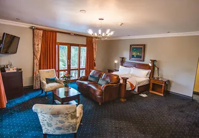 a hotel room with a bed and a couch at Village Ridge Stays in Pretoria