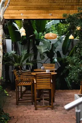 a wooden table and chairs on a patio at Village Ridge Stays in Pretoria