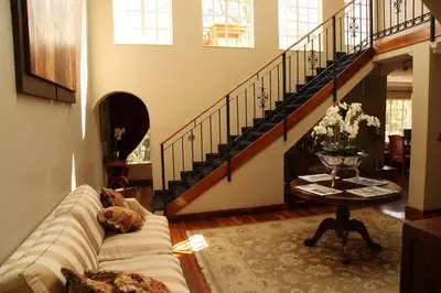 a living room with a couch and a staircase at Village Ridge Stays in Pretoria