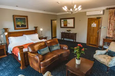 a hotel room with a bed and a couch at Village Ridge Stays in Pretoria