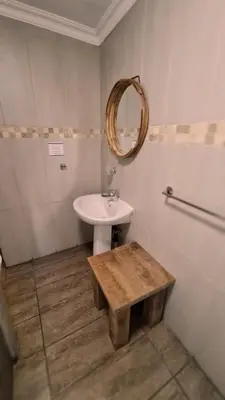 a bathroom with a sink and a mirror at Klein Bosveld Guest House in Witbank