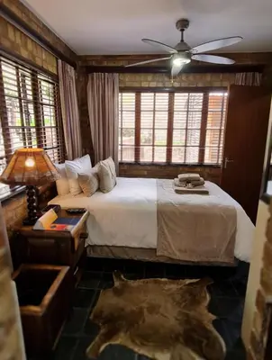 a bedroom with a bed and a ceiling fan at Klein Bosveld Guest House in Witbank