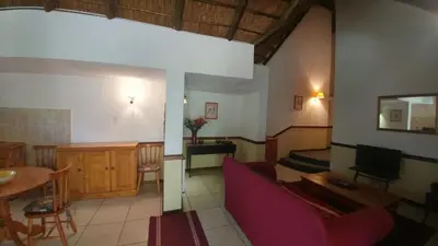a living room with a couch and a table at Oaktree Lodge Guest House in Kyalami