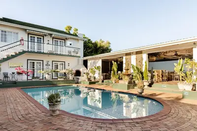 a swimming pool in front of a house at Shandon Lodge Guest House & Spa in Nelspruit