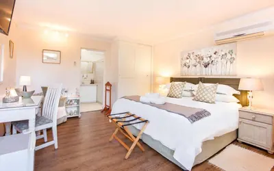 a bedroom with a large bed and a desk at Shandon Lodge Guest House & Spa in Nelspruit