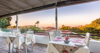 a table and chairs on a balcony with a view at Shandon Lodge Guest House & Spa in Nelspruit