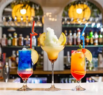 three cocktails sitting on a table in a bar at Shandon Lodge Guest House & Spa in Nelspruit