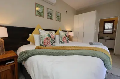 a bedroom with a large white bed with pillows at Hhusha Hhusha in Malelane