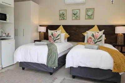 two beds sitting next to each other in a bedroom at Hhusha Hhusha in Malelane
