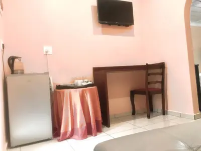 a room with a table and a tv on the wall at Ankuweni Guest house in Giyani
