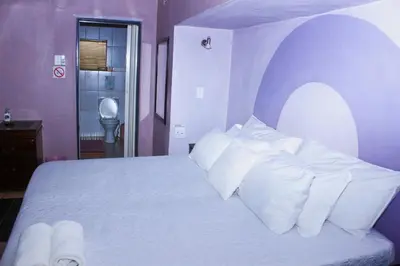 a bedroom with a white bed with white pillows at Ankuweni Guest house in Giyani
