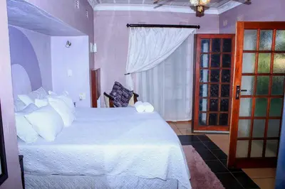 a bedroom with a white bed and a window at Ankuweni Guest house in Giyani
