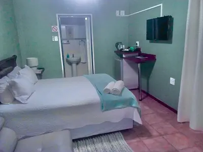 a bedroom with a large bed with towels on it at Ankuweni Guest house in Giyani