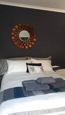 a bedroom with a large bed with a mirror on the wall at Oppermans Villa in Pretoria