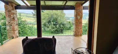 a room with a chair in front of a large window at Field and Stream in Dullstroom