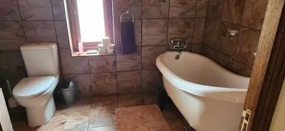 a bathroom with a tub and a toilet and a sink at Field and Stream in Dullstroom