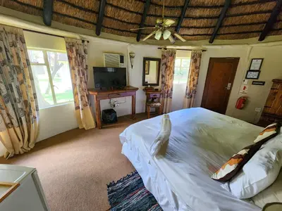 a bedroom with a large bed and a television at Ditholo Game Lodge Bela Bela in Bela-Bela