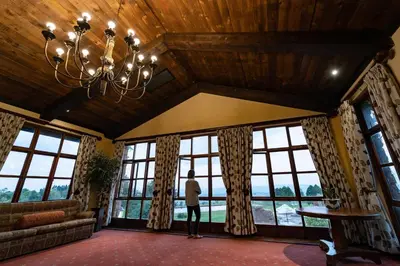 a person standing in a room with large windows at Gooderson Kloppenheim Country Estate in Machadodorp