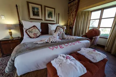 a bedroom with a large bed with towels on it at Gooderson Kloppenheim Country Estate in Machadodorp