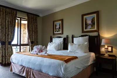 a bedroom with a large bed with a flower on it at Gooderson Kloppenheim Country Estate in Machadodorp
