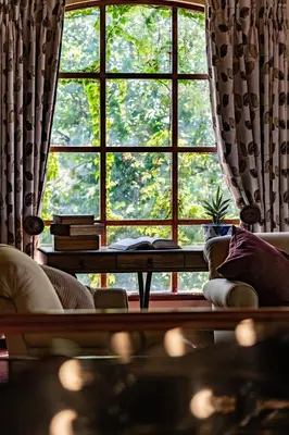 a living room with a large window and a table at Gooderson Kloppenheim Country Estate in Machadodorp