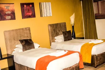 a hotel room with two beds with bear pillows at Coyotes Hotel & Conference Centre in Nelspruit