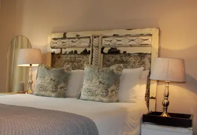 a bedroom with a large bed with two lamps at Blue Grass Nest in Nelspruit