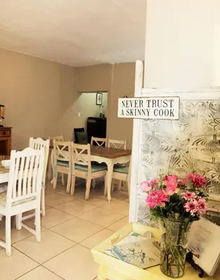 a vase of flowers on a table in a room at Blue Grass Nest in Nelspruit
