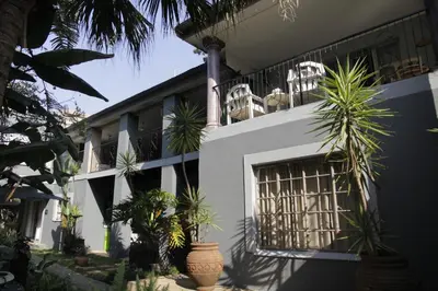 a white building with potted plants in front of it at Blue Grass Nest in Nelspruit