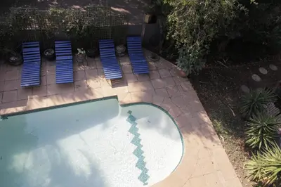 an overhead view of a swimming pool with blue chairs at Blue Grass Nest in Nelspruit