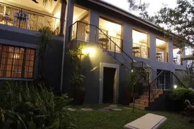 a house with stairs and a balcony at Blue Grass Nest in Nelspruit