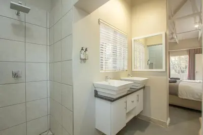 a white bathroom with a sink and a mirror at 3433 on Klipspringer Marloth Park Kruger in Marloth Park