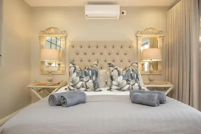 a bedroom with a large white bed with two lamps at 3433 on Klipspringer Marloth Park Kruger in Marloth Park