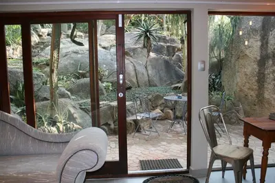 a room with a sliding glass door with a patio at Klipkoppie Cottage in Nelspruit