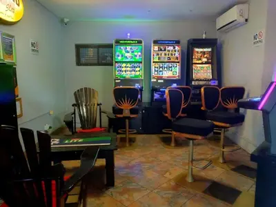 a gaming room with two slot machines and chairs at Elegant Guest House Malelane in Malelane