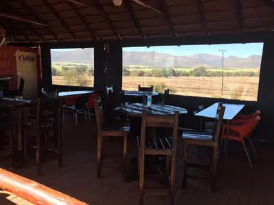 a restaurant with tables and chairs and a view of a field at Elegant Guest House Malelane in Malelane