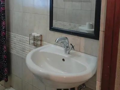a white sink in a bathroom with a mirror at Elegant Guest House Malelane in Malelane