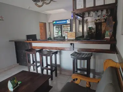 a bar in a restaurant with three bar stools at Elegant Guest House Malelane in Malelane
