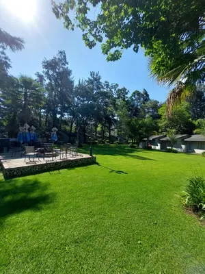 a park with tables and chairs in the grass at Wayside Lodge in Waterval Boven
