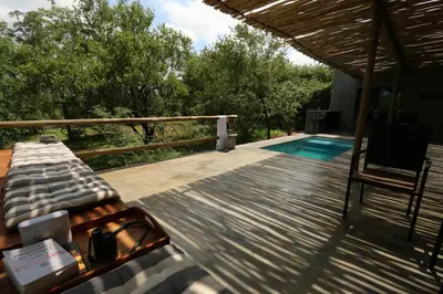 a deck with a chair and a swimming pool at Kruger Willows in Marloth Park