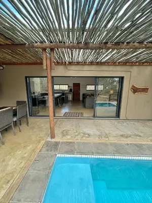 a swimming pool in the middle of a house at Kruger Willows in Marloth Park