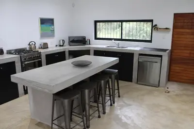 a kitchen with a large island with bar stools at Kruger Willows in Marloth Park
