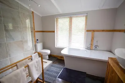 a bathroom with a tub and a toilet and a sink at Van De Poll House in Dullstroom