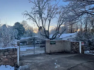 a gate with a stone fence in the snow at Van De Poll House in Dullstroom