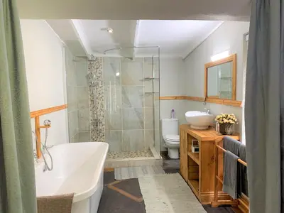 a bathroom with a tub and a sink and a toilet at Van De Poll House in Dullstroom