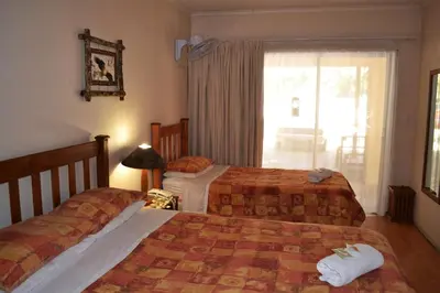 a hotel room with two beds and a window at Dove's Nest Guest House in Kempton Park