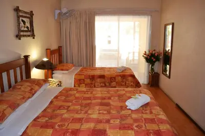 a hotel room with two beds and a window at Dove's Nest Guest House in Kempton Park