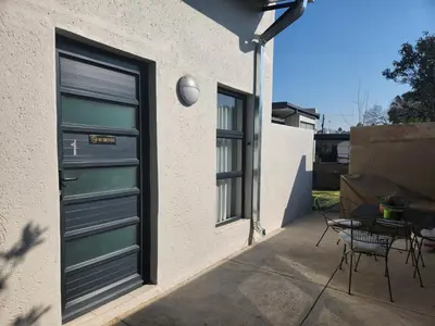 a door on a building with a table and a patio at 9 Levubu Cottages in Polokwane